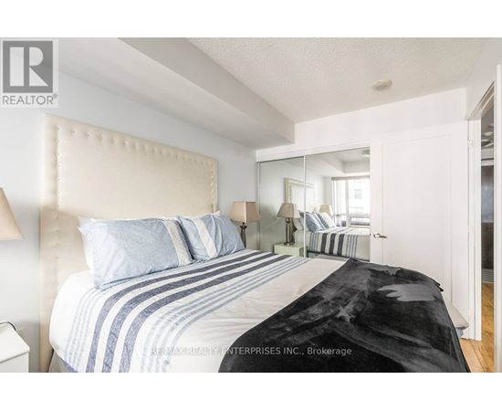 A bedroom with a large bed and a mirror on the wall.