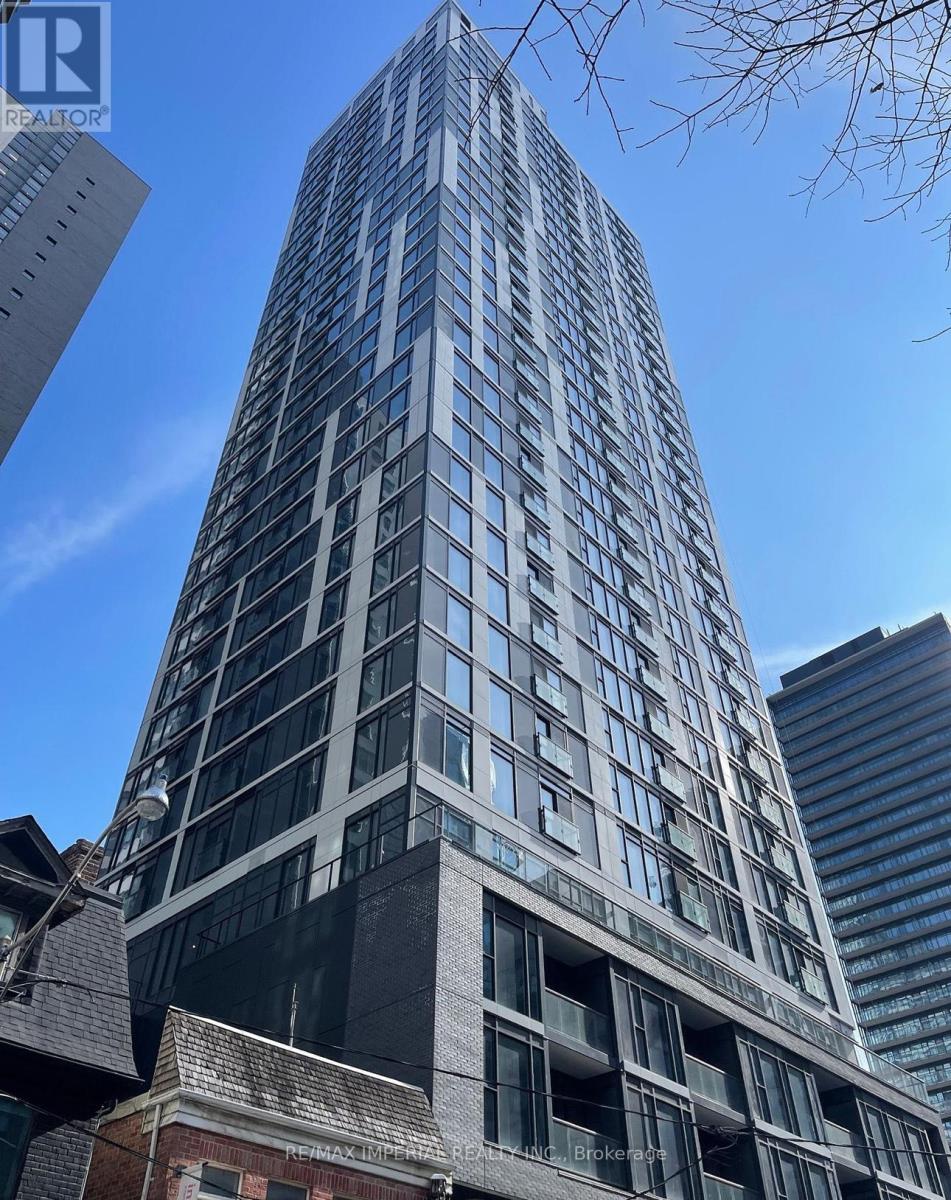 A tall building with many windows is under a clear blue sky.