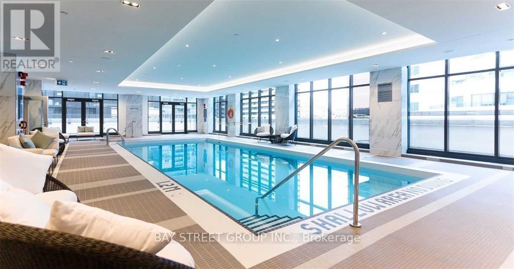 A large indoor swimming pool with a glass wall on one side.
