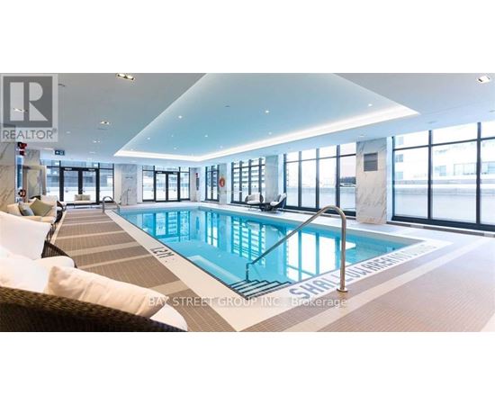 A large indoor swimming pool with a glass wall on one side.