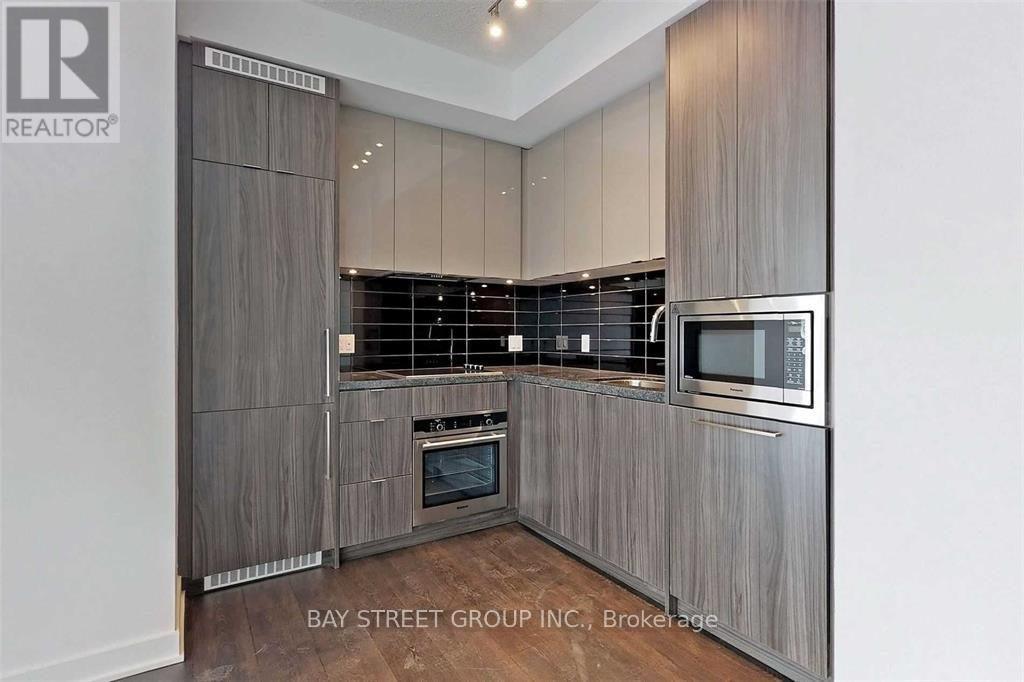 A modern kitchen with wooden cabinets and stainless steel appliances.