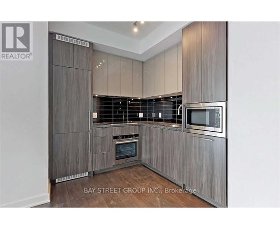 A modern kitchen with wooden cabinets and stainless steel appliances.