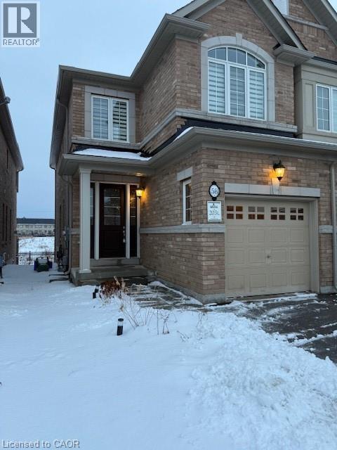 A house with a garage and a driveway covered in snow.