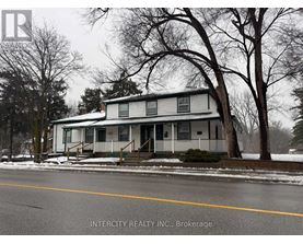A house with a white siding and a porch is shown in the image.