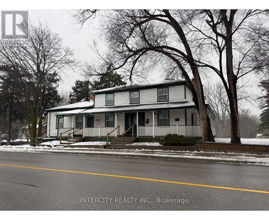 A house with a white siding and a porch is shown in the image.