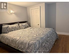 A bedroom with a bed, pillows, and a door.