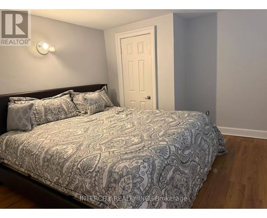 A bedroom with a bed, pillows, and a door.