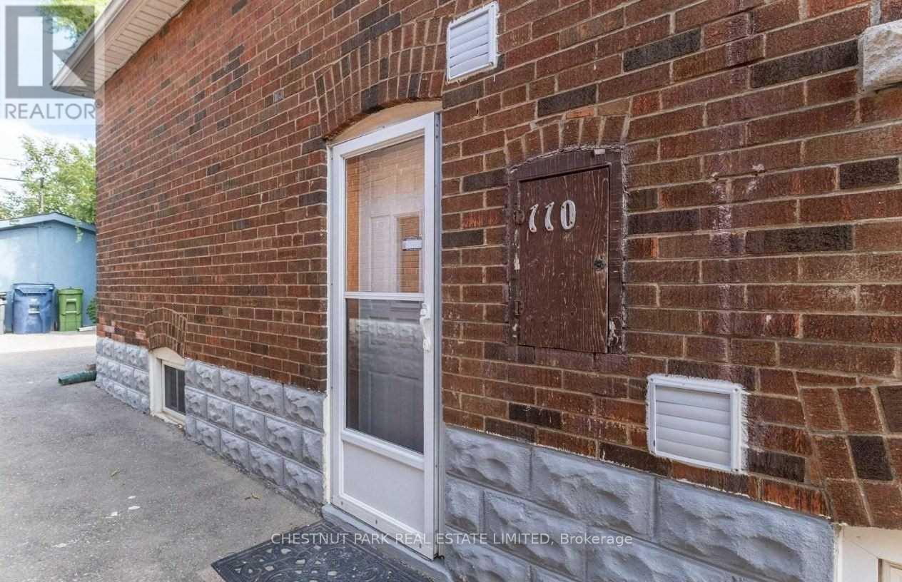 A brick building with a door and a sign that says "110".