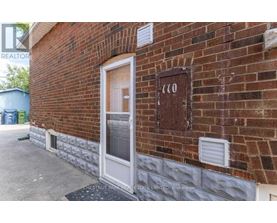 A brick building with a door and a sign that says "110".