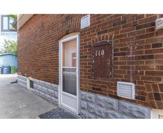 A brick building with a door and a sign that says "110".
