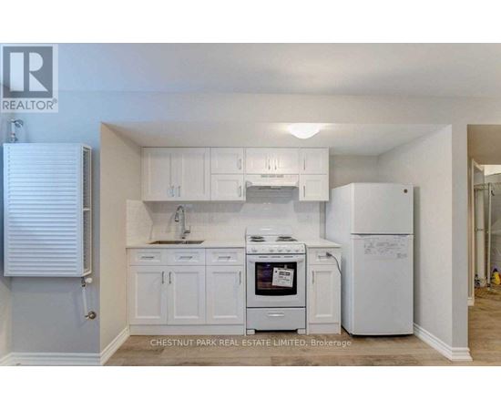 A kitchen with white cabinets and appliances, including a stove and a refrigerator, is on the market with Chestnut Park Real Estate Limited.