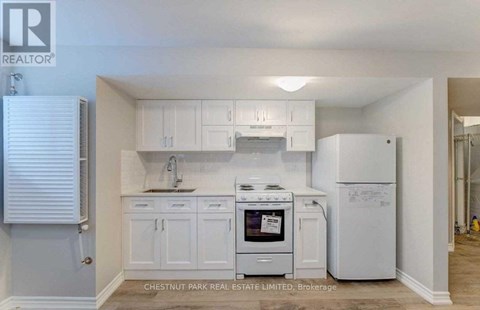 A kitchen with white cabinets and appliances, including a stove and a refrigerator, is on the market with Chestnut Park Real Estate Limited.