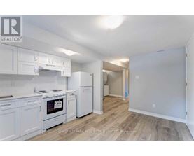 A kitchen with white appliances and cabinets in a real estate listing.