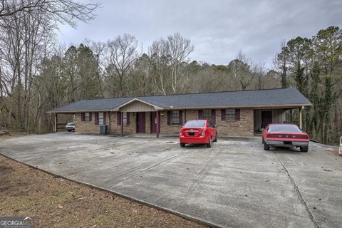 A house with a red car parked in front of it.
