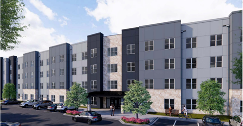A modern apartment complex with a parking lot in front.