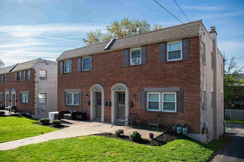 A row of houses with a green lawn in front.