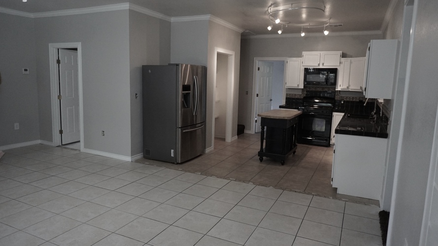 A kitchen with a refrigerator, oven, and stove.