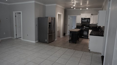 A kitchen with a refrigerator, oven, and stove.