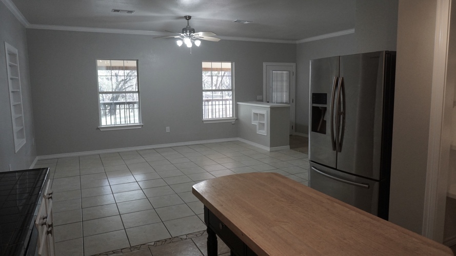 A kitchen with a refrigerator, sink, and a table.