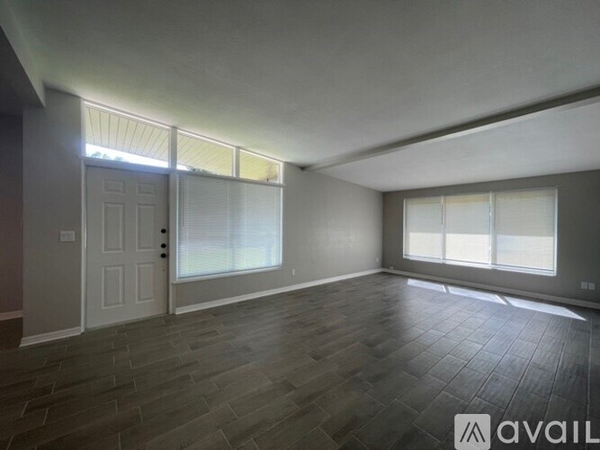 A spacious room with a door and windows.