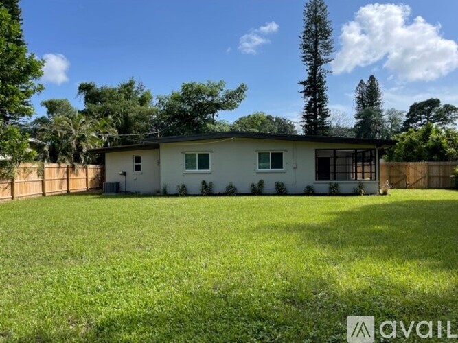 A house with a fence and trees in the background.