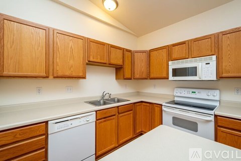 A kitchen with wooden cabinets and white appliances.