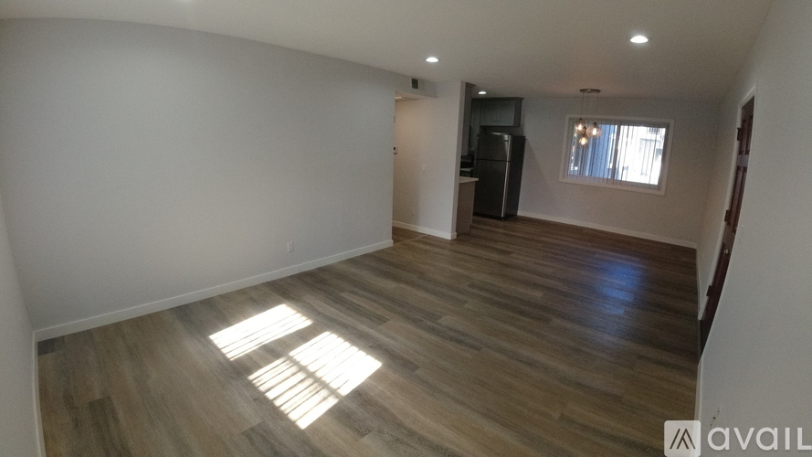 A room with wooden flooring and a window letting in natural light.