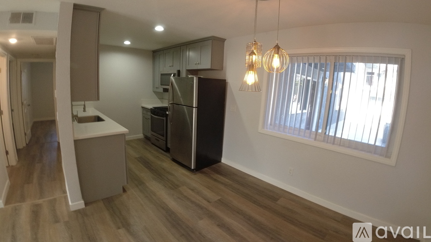 A kitchen with wooden floors and a refrigerator.