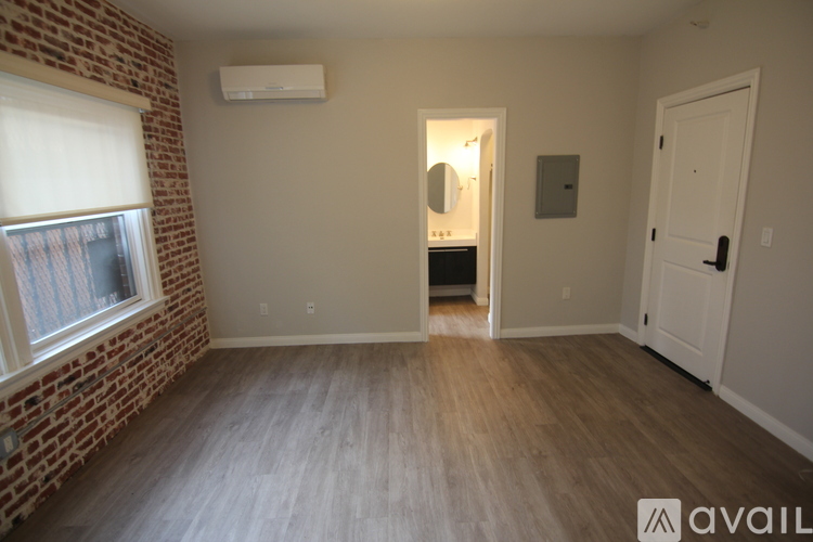 A room with a brick wall and wooden flooring.
