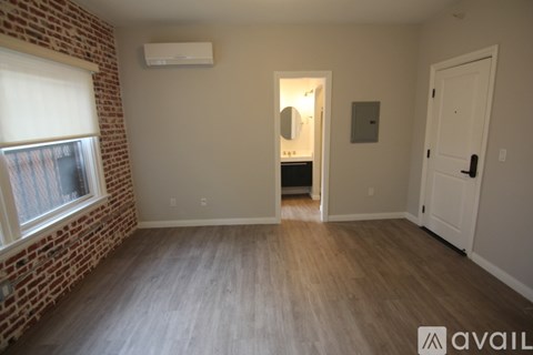 A room with a brick wall and wooden flooring.