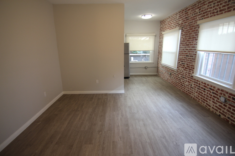A room with wooden flooring and a brick wall.