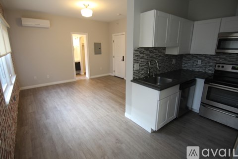 A kitchen with white cabinets and a black countertop.