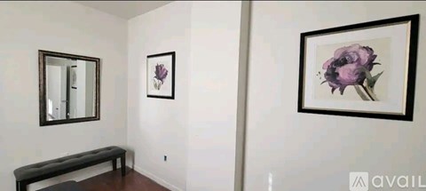 A hallway with a bench and two framed pictures on the wall.