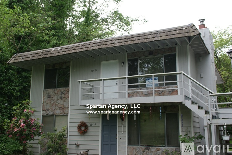 A house with a balcony and a garage door is for sale.