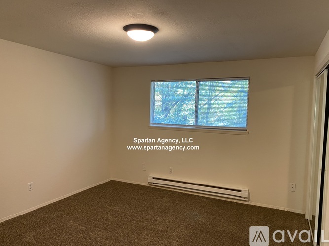 A Spartan Agency office room with a window and a carpeted floor.