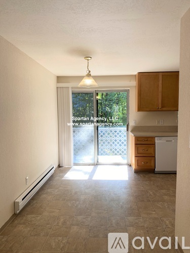 A room with a window and a view of trees outside.