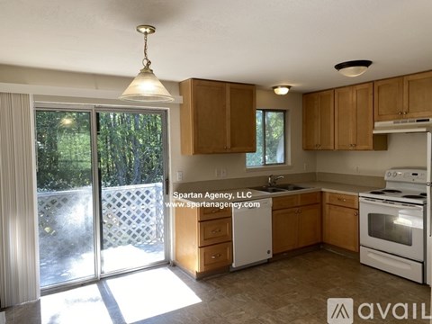 A kitchen with wooden cabinets and a white stove top oven.