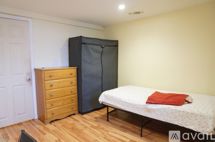 A bedroom with a bed, a dresser, and a wardrobe.
