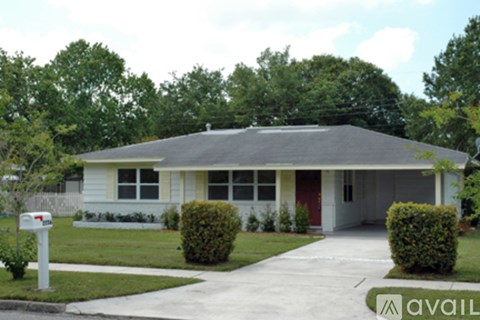 A house with a red door and a mailbox in front.