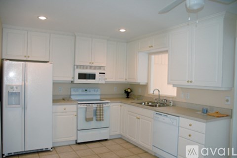 A kitchen with white appliances and cabinets.