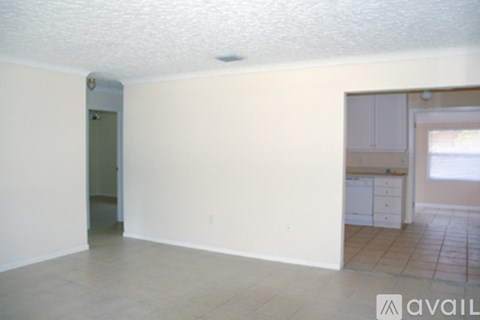 A room with a tile floor and a doorway leading to another room.