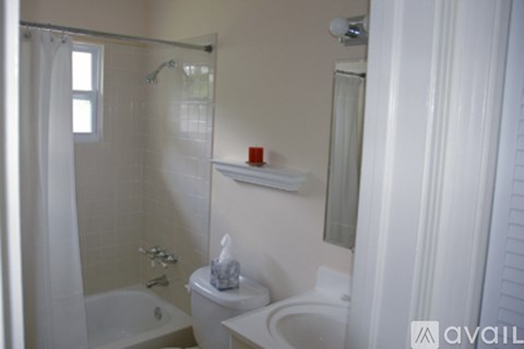 A white bathroom with a toilet, sink, and bathtub.