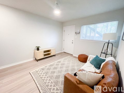 A living room with a brown leather couch and a wooden coffee table.