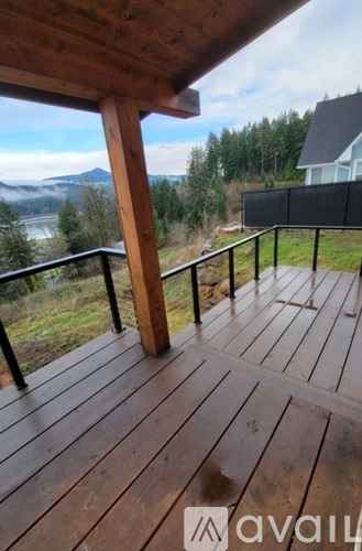 A wooden deck with a railing and a view of the mountains.