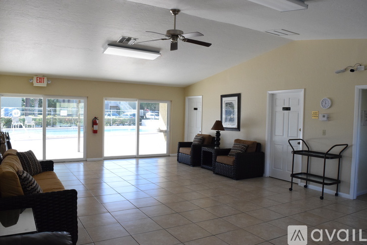 A spacious living room with a sofa set, a chair, and a fan.