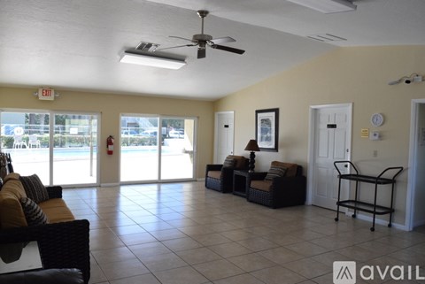 A spacious living room with a sofa set, a chair, and a fan.
