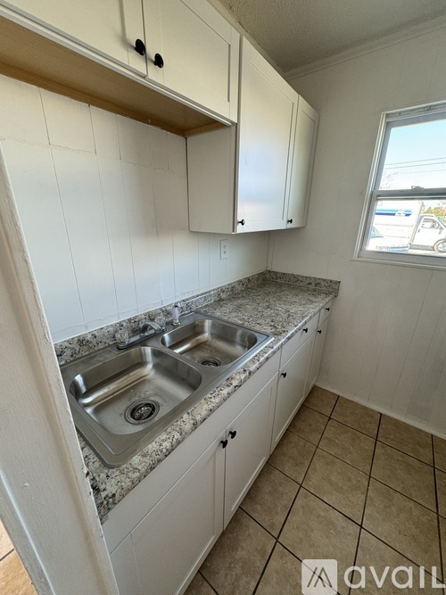 A kitchen with a granite countertop and white cabinets.