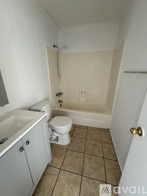 A bathroom with a toilet, sink, and bathtub.