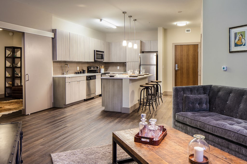 a living room and kitchen with a couch and a table