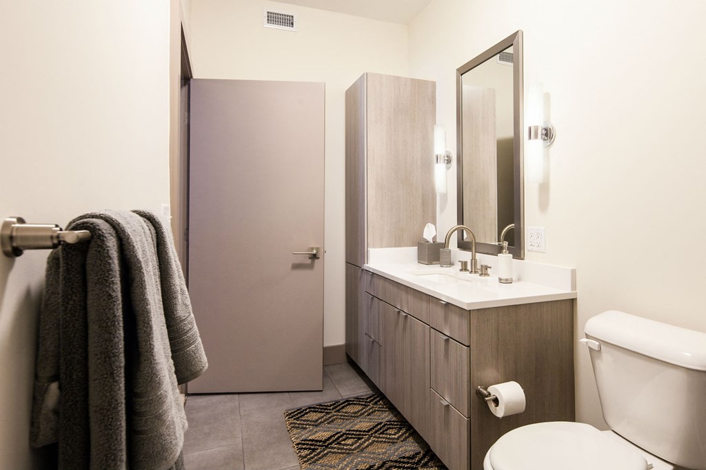 a bathroom with a toilet sink and mirror and a shower